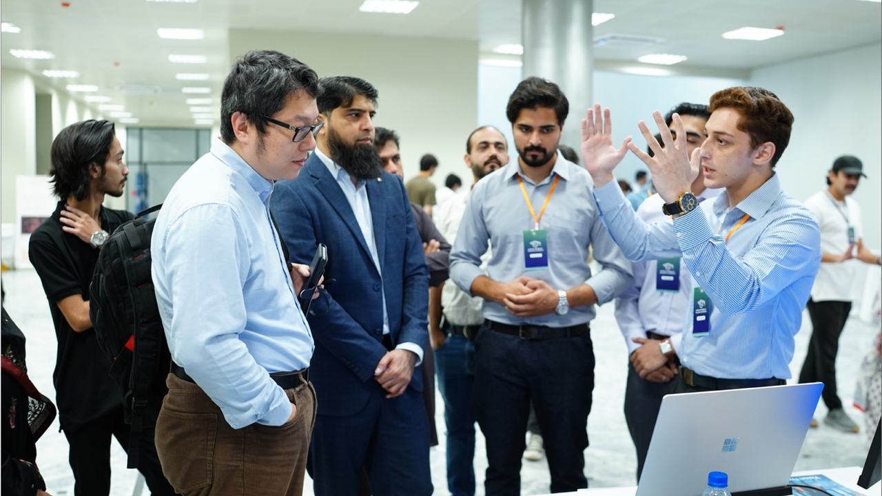 A finalist demoing a project on a laptop to attendees